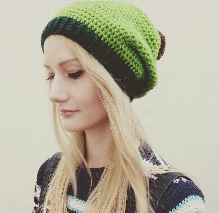 woman wearing a green crochet hat with brown pompom