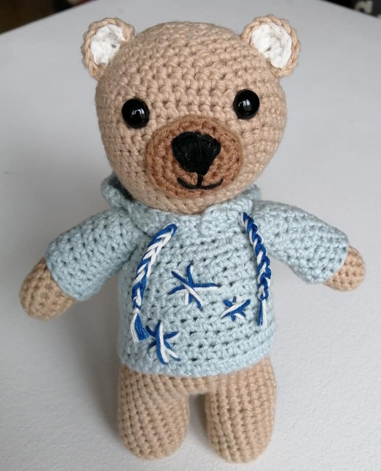crochet light brown teddy bear wearing a light blue jumper