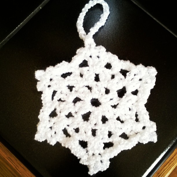 white crochet snowflake on black tile